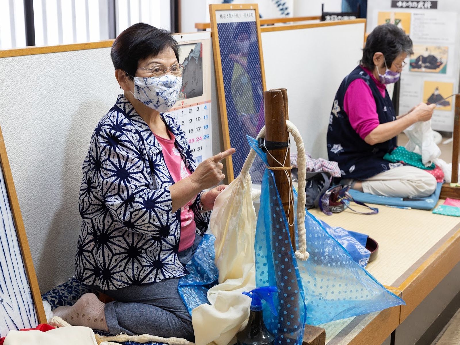 Two local women talking about kukuri binding while their hands keep working